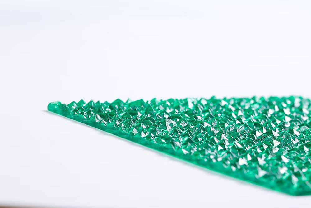 15f69d041c2f31fee6d8c1b26d8f5702 - Close-up of a bright green, spiked craft mat with pyramid-shaped bumps used for grip or texture.