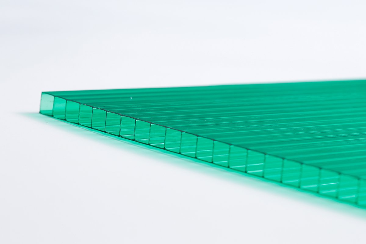 2c13ecbf4776901f647aaab8564ed814 - Close-up of a green translucent plastic sheet with a ribbed edge on a white background.