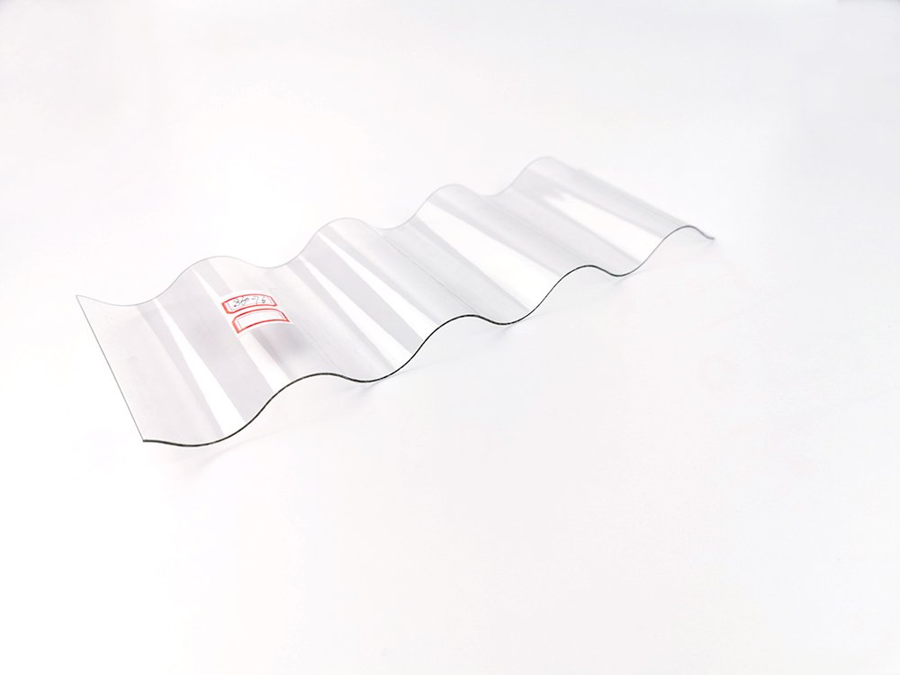 Transparent corrugated plastic sheet with alternating waves laid on a white surface.