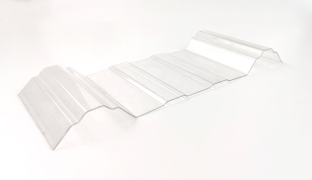 Metal corrugated roofing panel laid on a white surface with multiple ridges and bends.