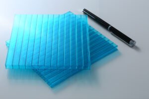 微信图片_20260413135453_422_159 - Blue transparent plastic sheets stacked in overlapping layers with a black pen beside them on a white surface.