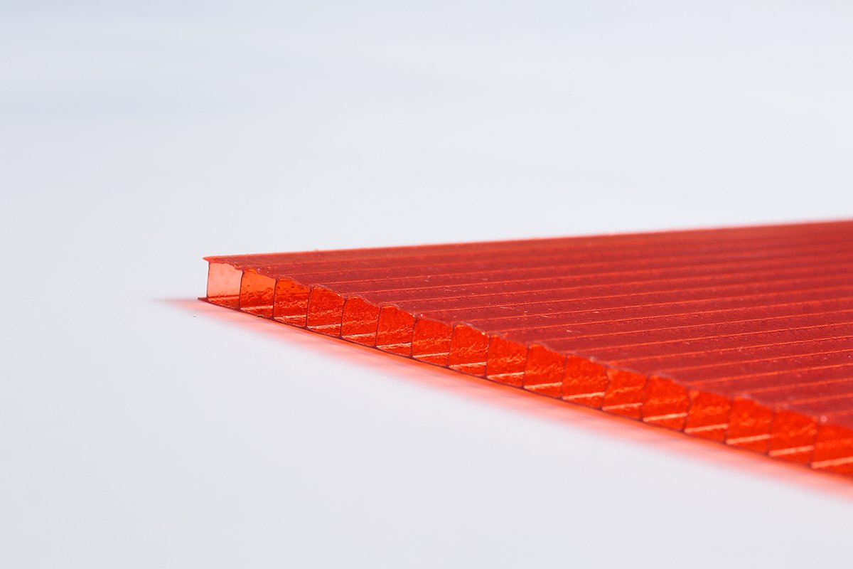 微信图片_20260413135457_426_159 - Close-up of a red translucent plastic ruler with parallel ridges along the edge on a white surface.