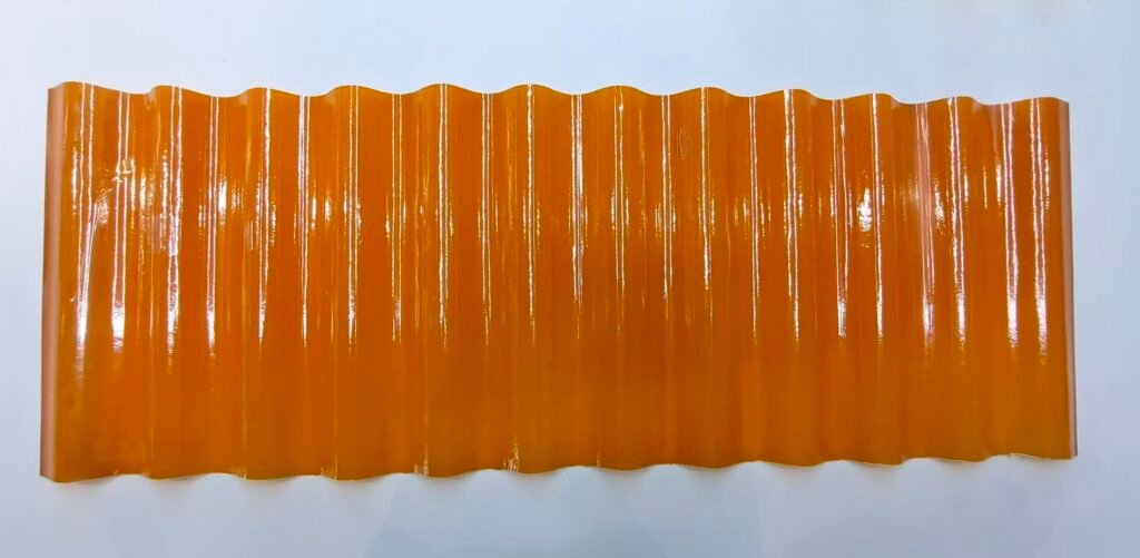 Orange glossy corrugated panel with vertical ridges, viewed head-on against a pale background, top edge wavy.