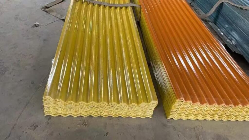 af92e5e8f977e81e73f0da6919319f61 - Yellow and orange corrugated panels stacked on a concrete floor, glossy finish, ready for installation in a construction site.
