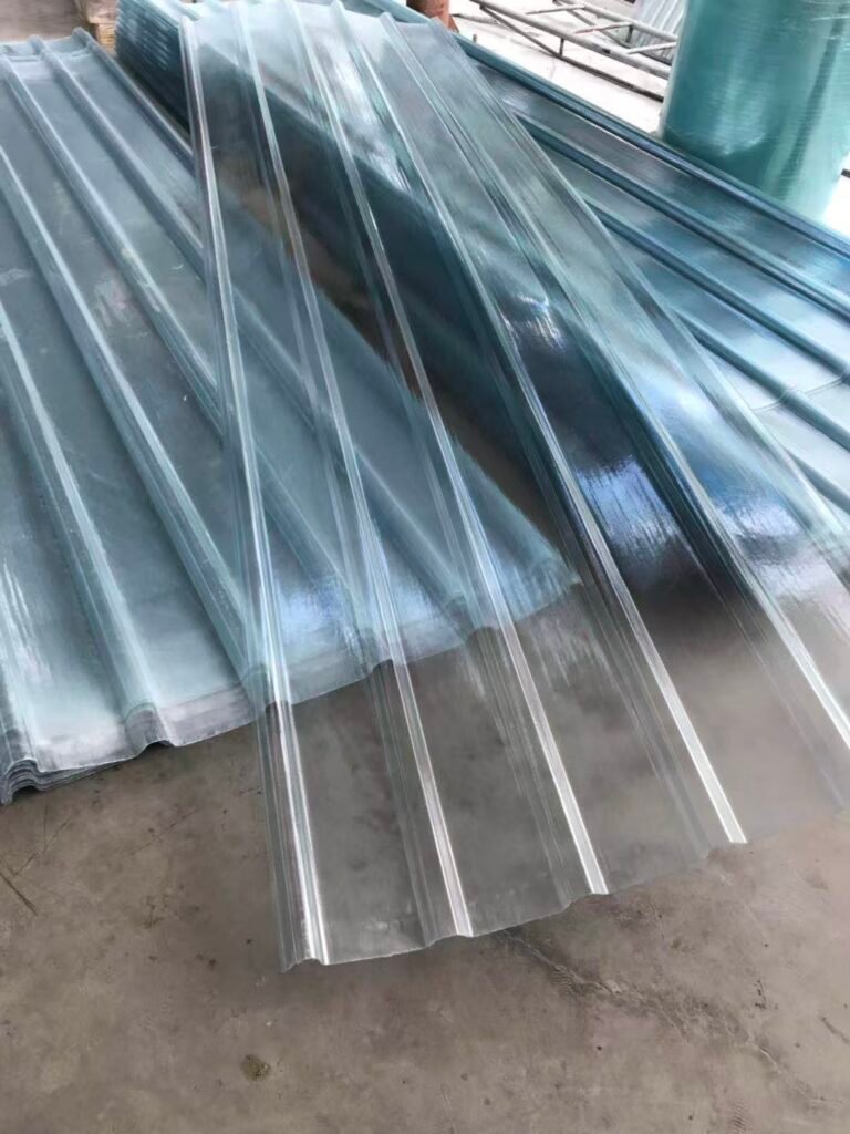 bef79a9094bf439c041da18e12e18d82 - Stacked shiny corrugated metal roofing panels on a concrete floor, ready for installation.