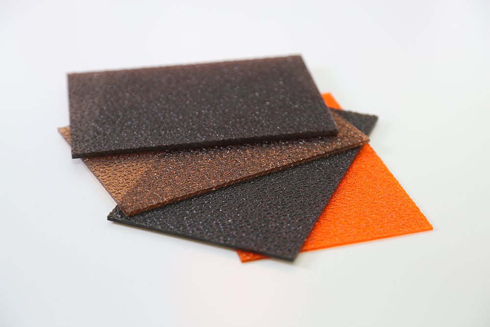微信图片_20260413135420_387_159 - Stack of textured leather swatches in brown, black, and orange on a white background.