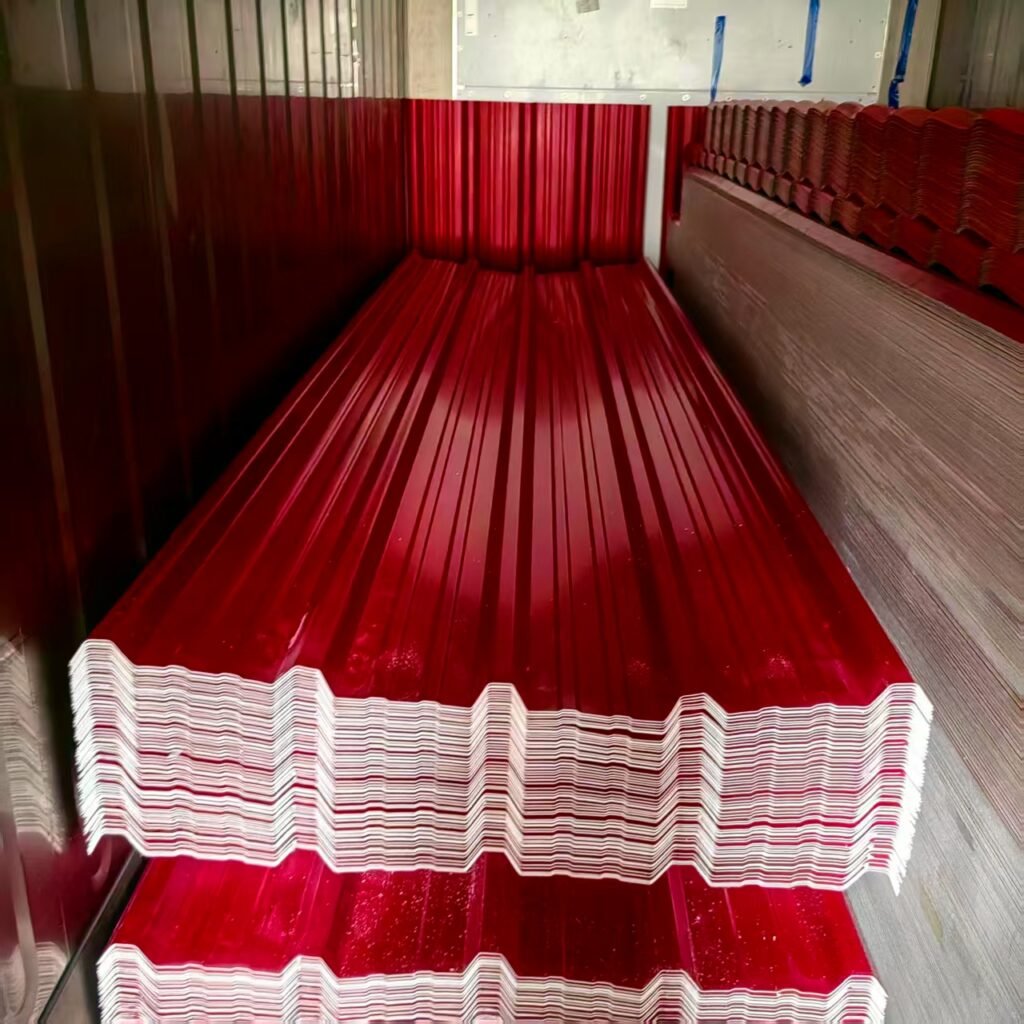 Stacks of red corrugated metal roofing sheets stacked in a warehouse area, seen from a low angle left-to-right edge.